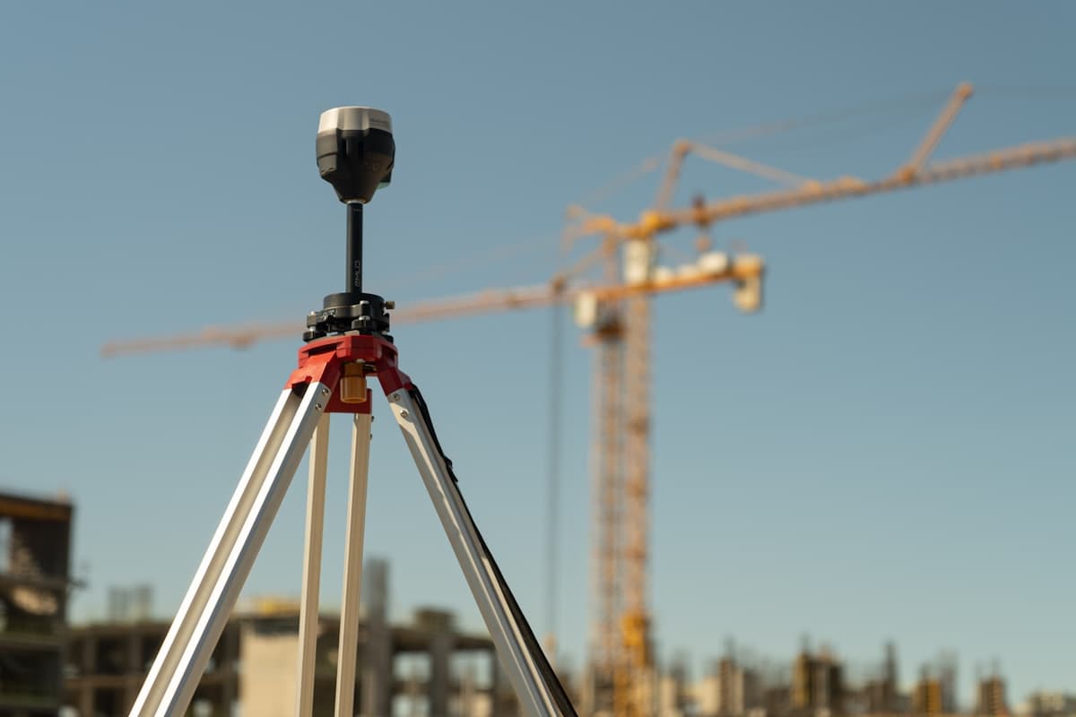 Meetinstrument op statief met een bouwkraan op de achtergrond